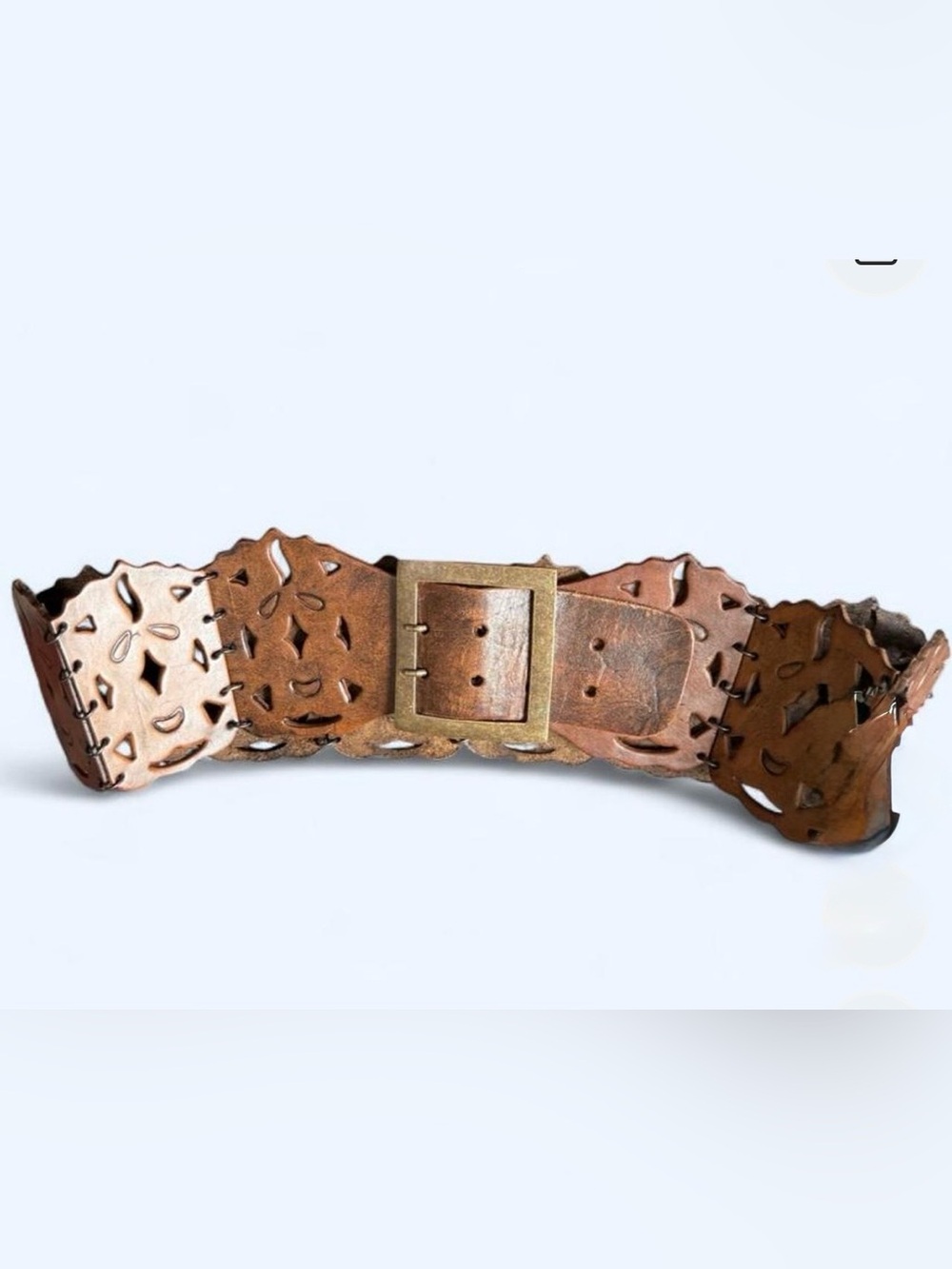 Brown  belt with cut-out geometric shapes and brass buckle.